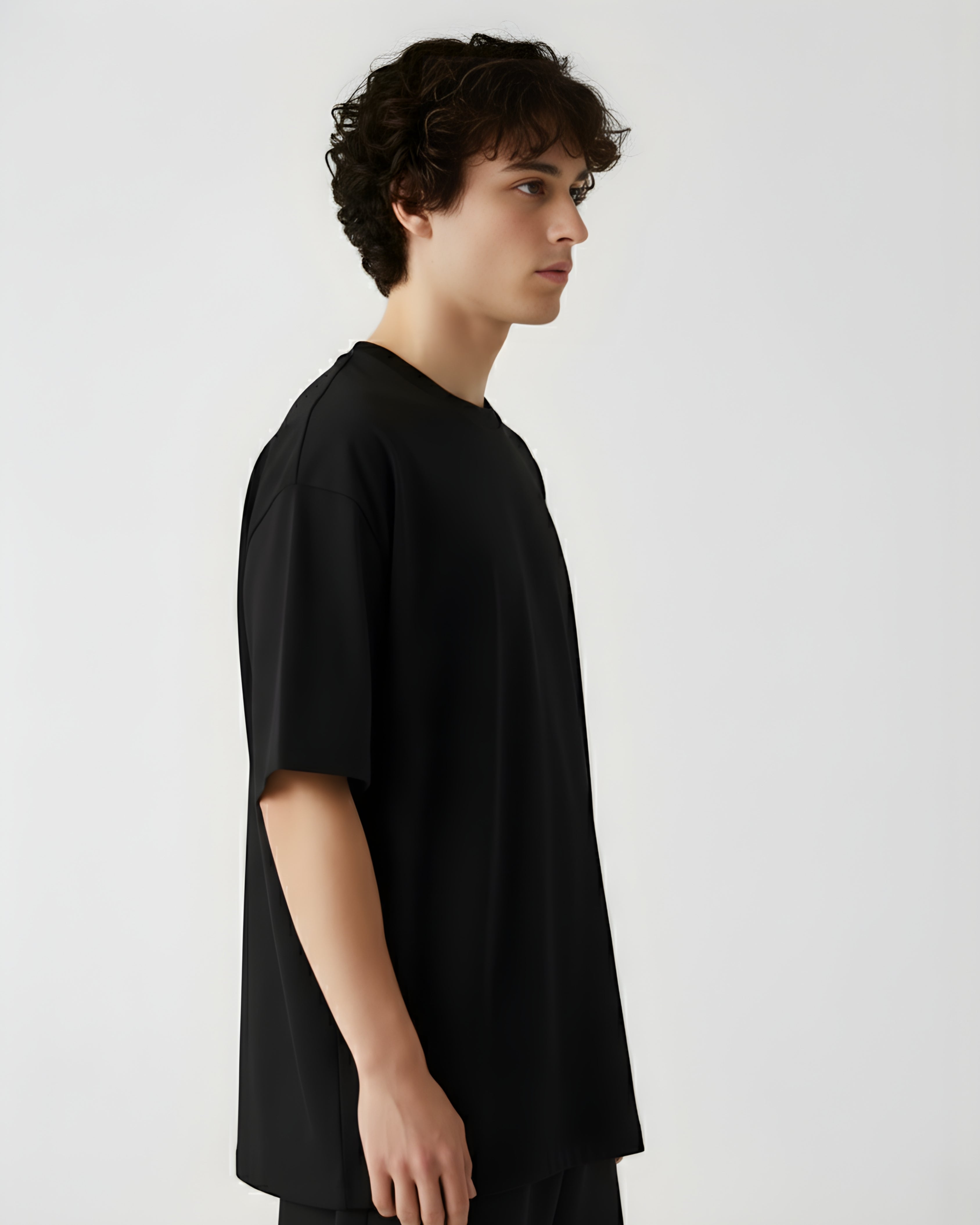 Person wearing a black t-shirt against a white background