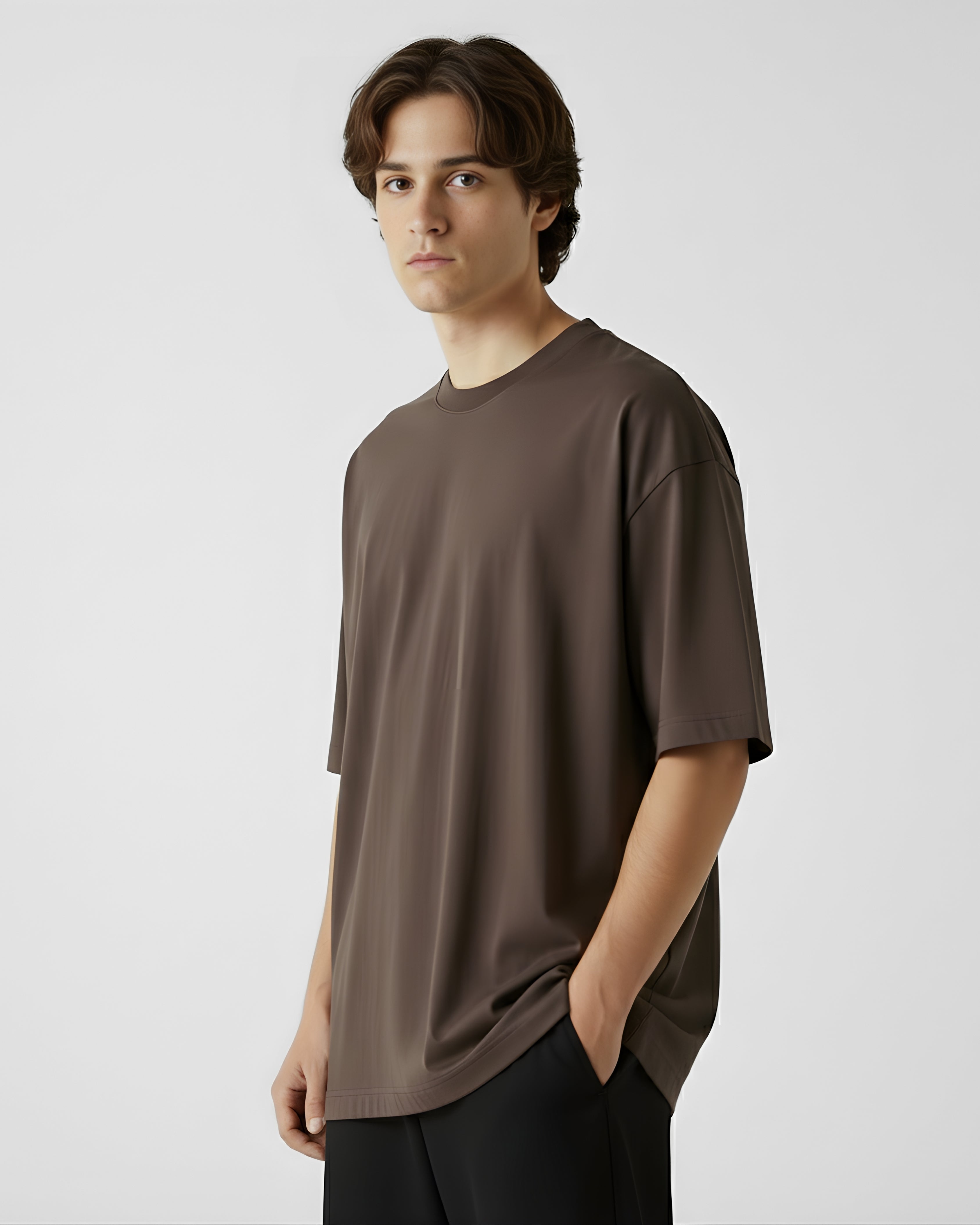 Person wearing a brown oversized tshirt against a plain background