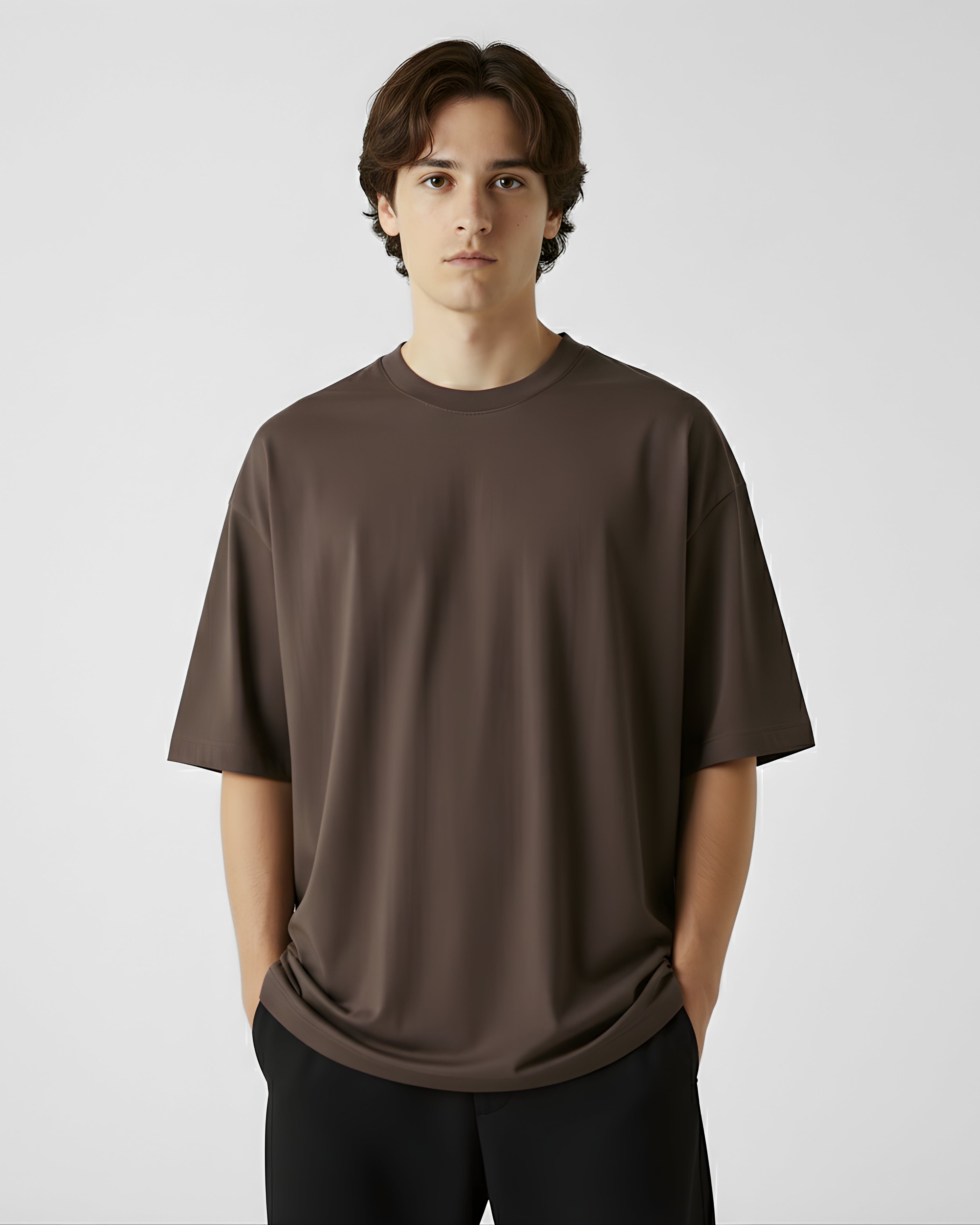 Person wearing a brown outfit sitting on a white surface with a minimal background