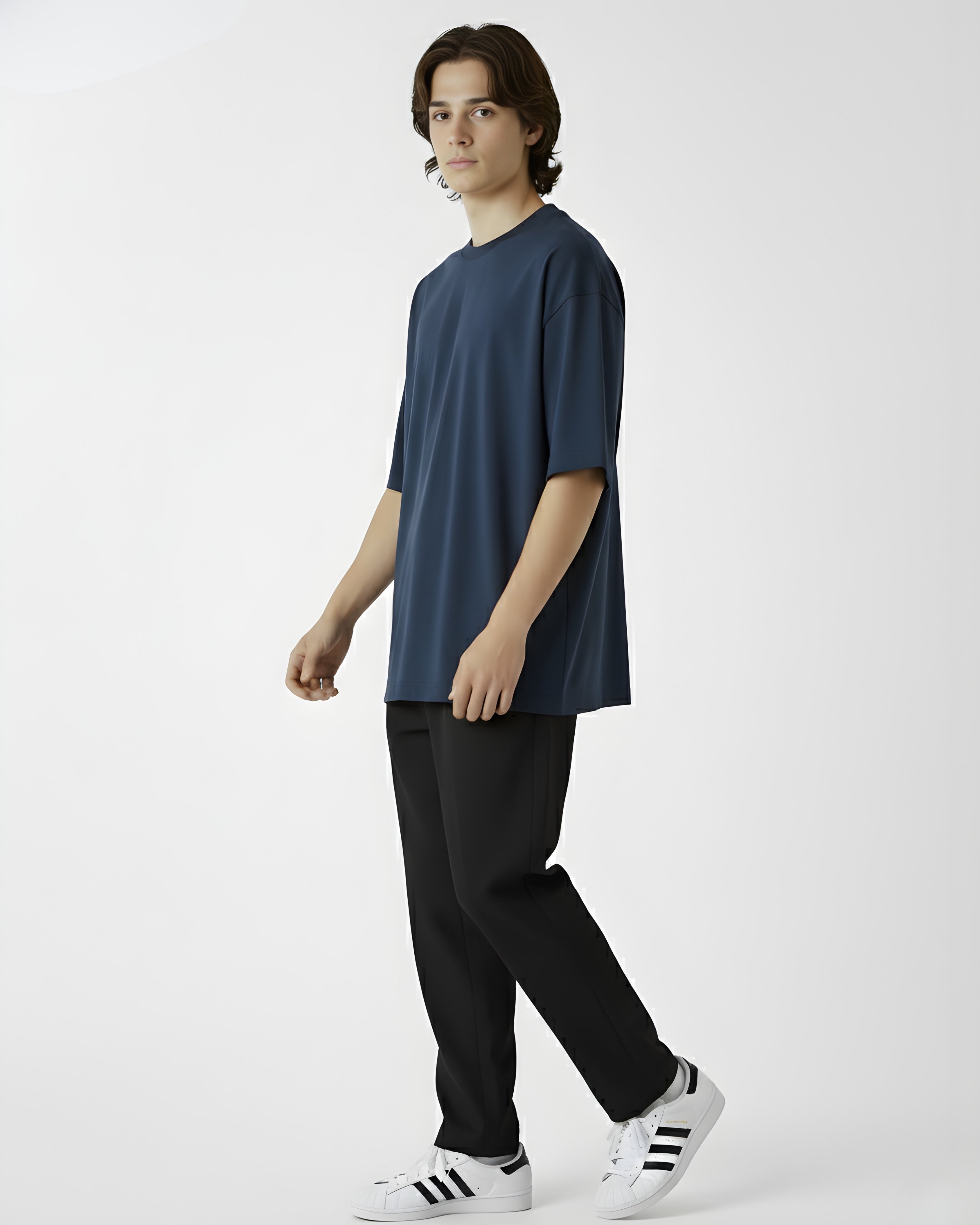 Person wearing a navy blue t-shirt and black pants with white sneakers on a white background