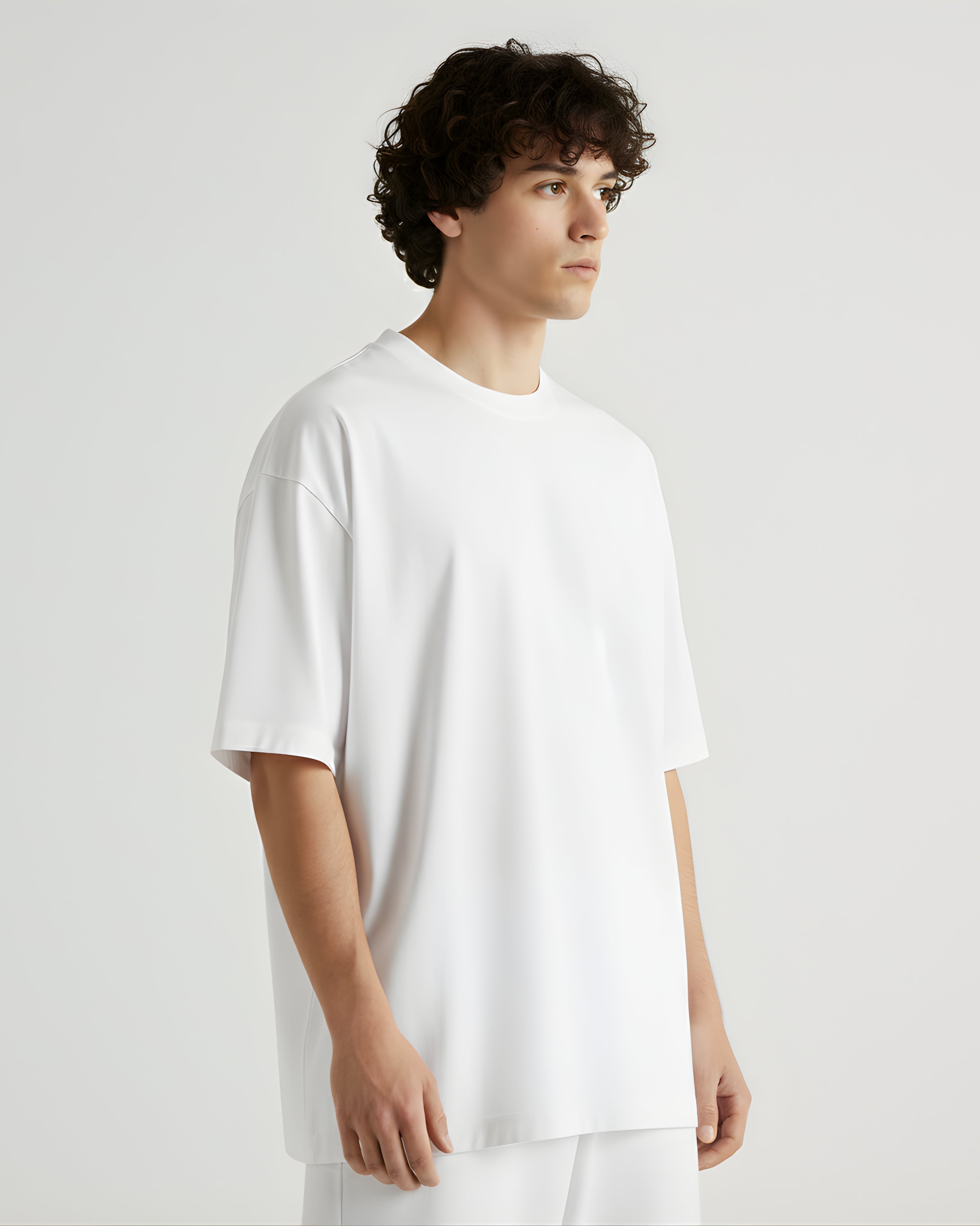 Person wearing a white oversize tshirt on a plain background
