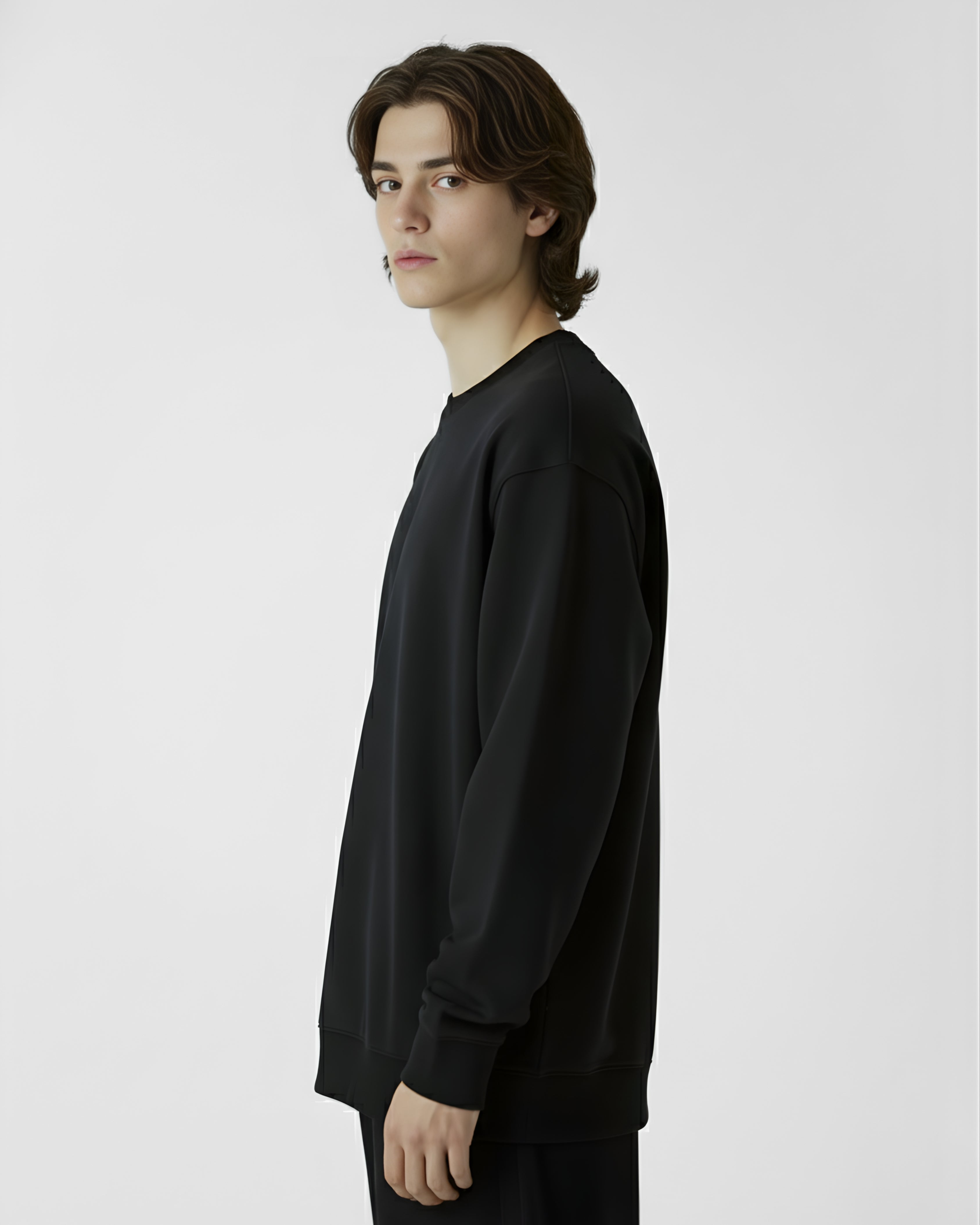 Person wearing a black long-sleeve shirt against a plain background