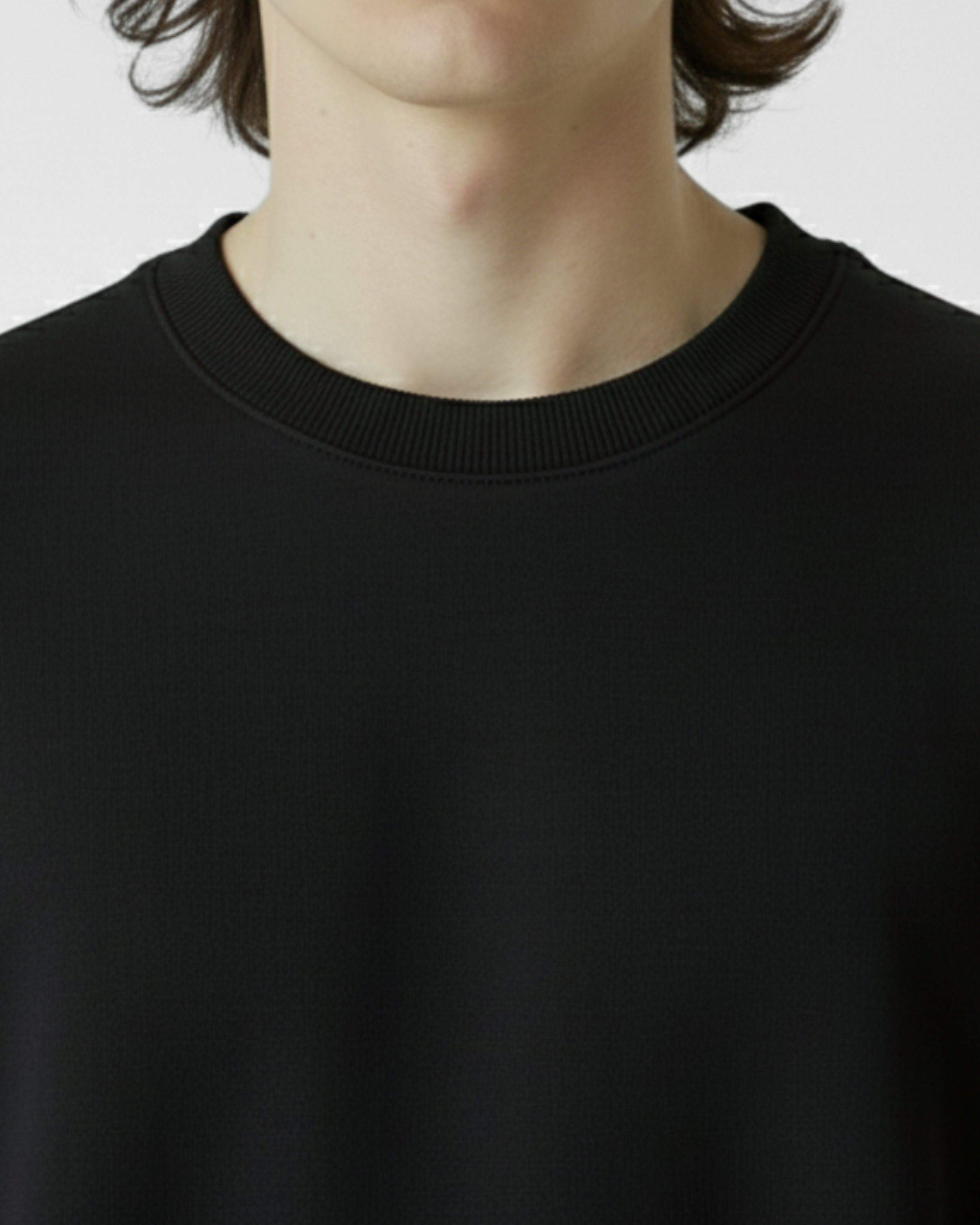 Black sweater worn by a person on a plain background