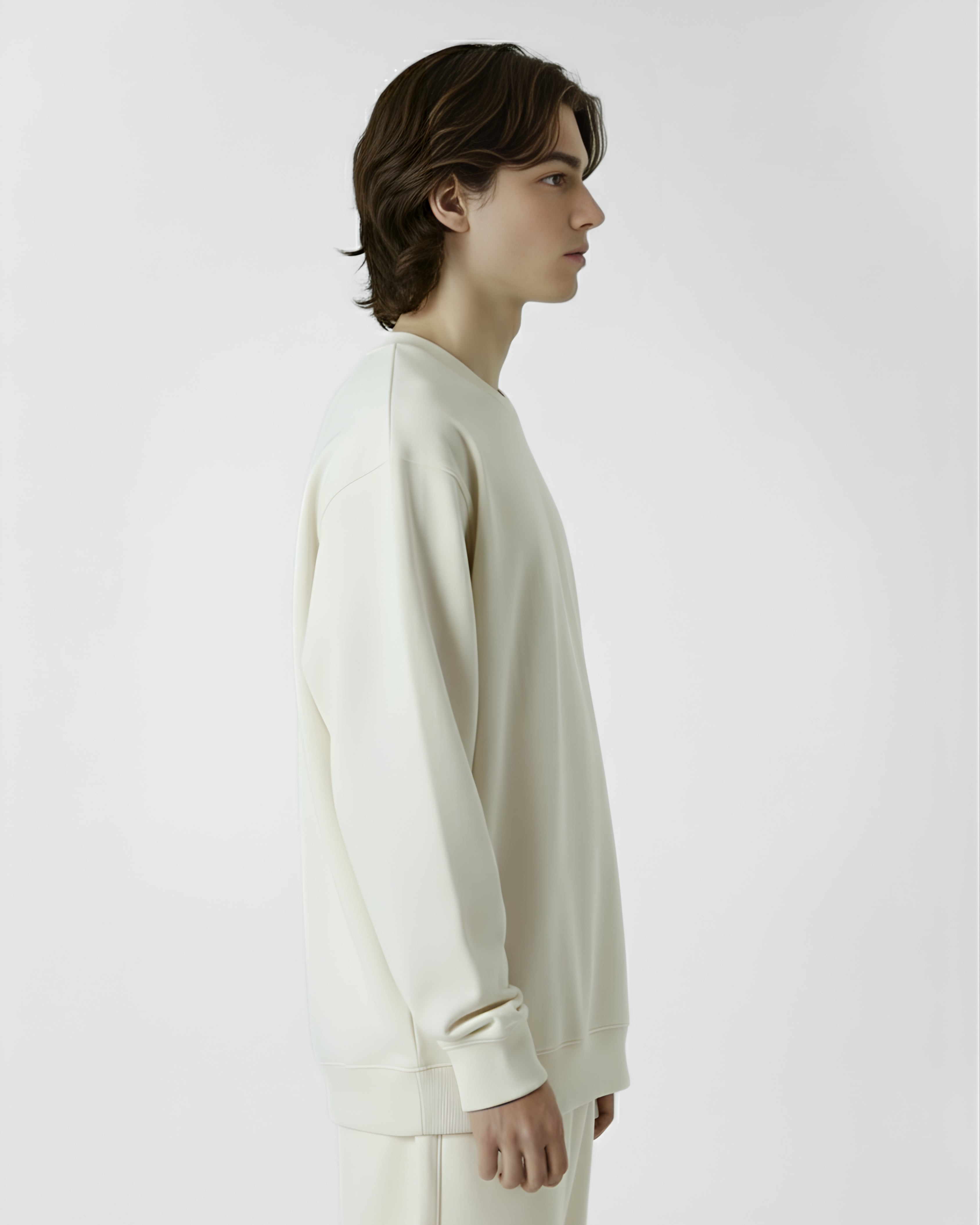 Person wearing a white long-sleeve shirt against a plain background